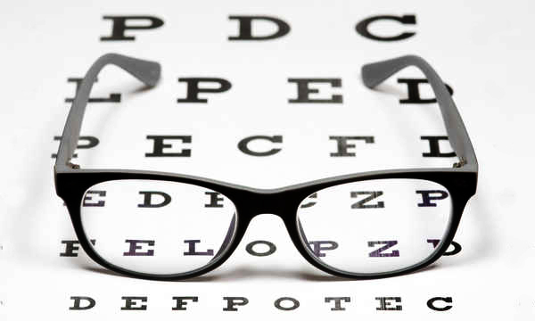 Opticien présentant des montures de lunettes à un client à domicile